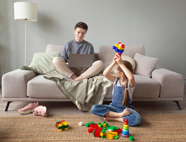 Full shot parent working on laptop