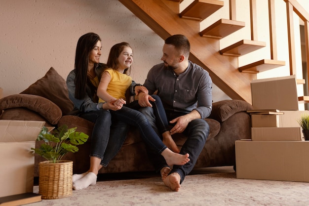 Full shot parents and kid on couch