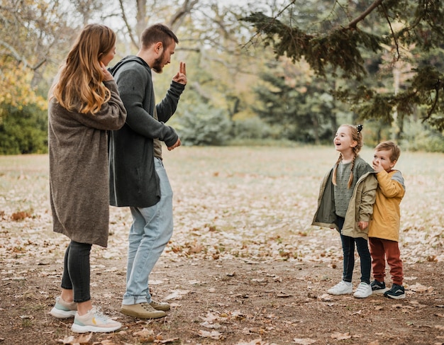 Full shot parents and kids outdoors