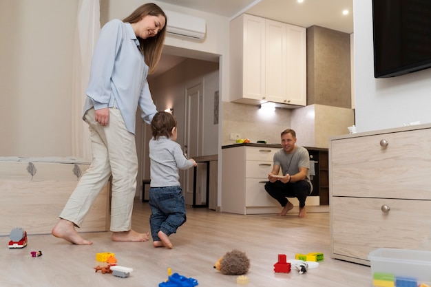 子供の最初のステップを見ているフルショットの親