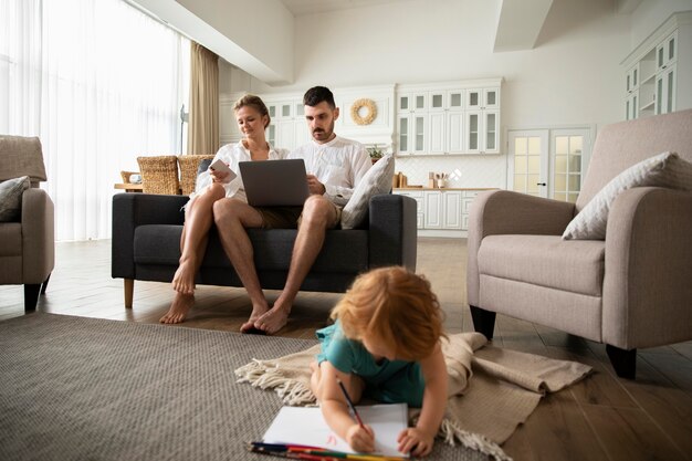 full shot parents with laptop at home