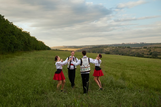 Foto gratuita persone a tutto campo che ballano nella natura