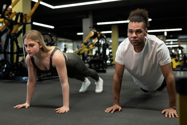 Full shot people doing burpees at gym