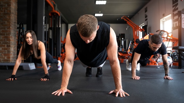 Full shot people doing burpees together