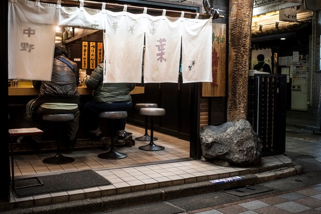 Люди в полный рост едят в ресторане японской уличной еды