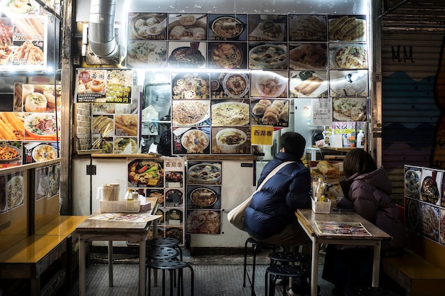 日本の屋台のレストランで食べるフルショットの人々