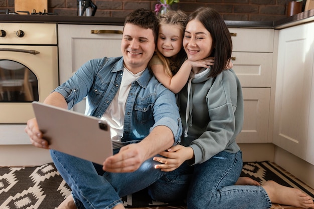 Full shot people on floor with tablet