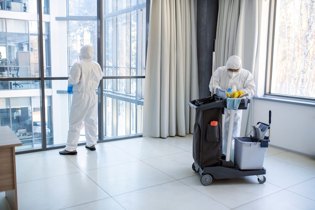 Free photo full shot people in hazmat suit cleaning