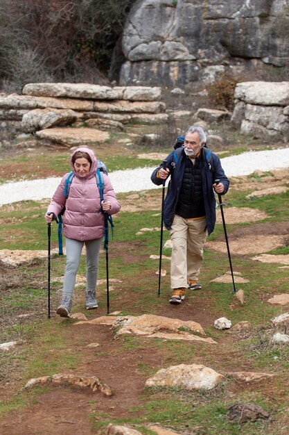 Full shot people hiking with equipment