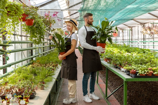 Free photo full shot people holding plants