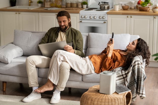 Full shot people laying on couch