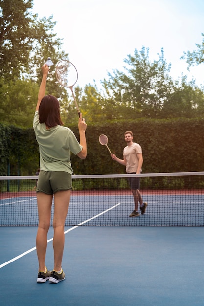 Full shot people playing badminton