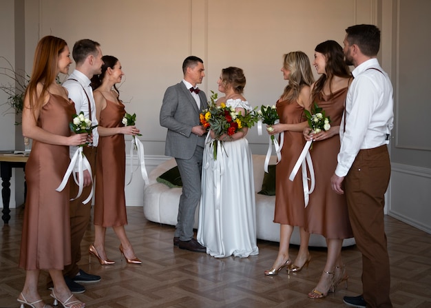 Foto gratuita persone a tutto campo in posa al matrimonio