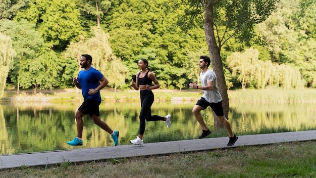 Free photo full shot people running together in nature