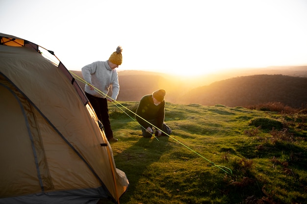 Full shot people setting up tent