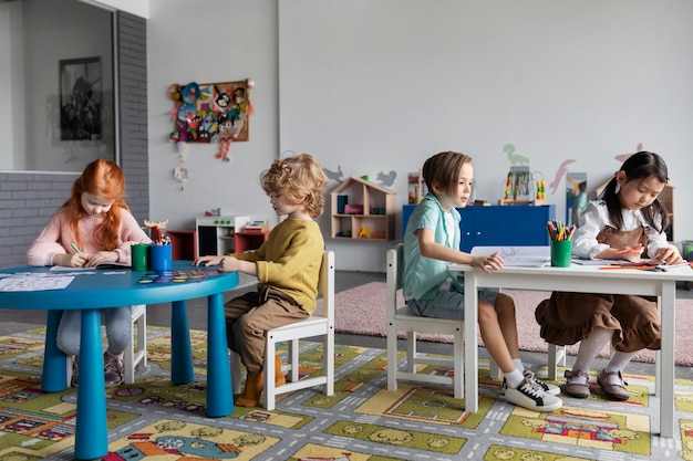 Full shot people sitting on chairs at kindergarten