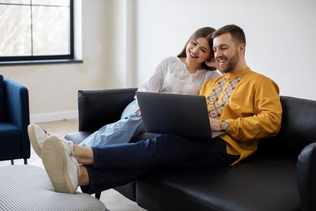 Full shot people sitting on couch