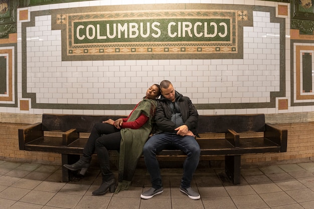 Free photo full shot people sleeping together on bench