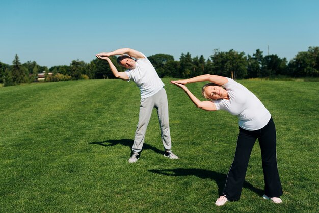 Full shot  people stretching outdoors