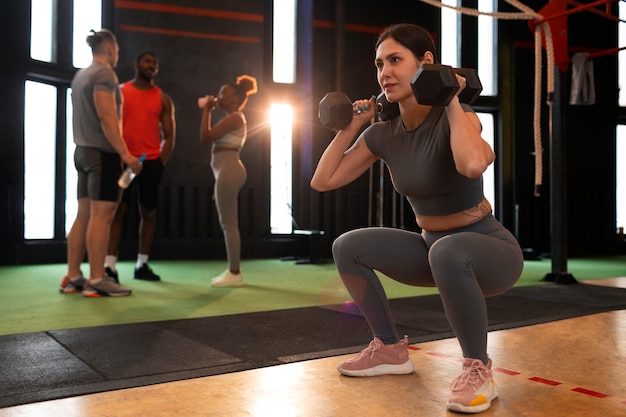 Foto gratuita persone a tutto campo che si allenano insieme in palestra