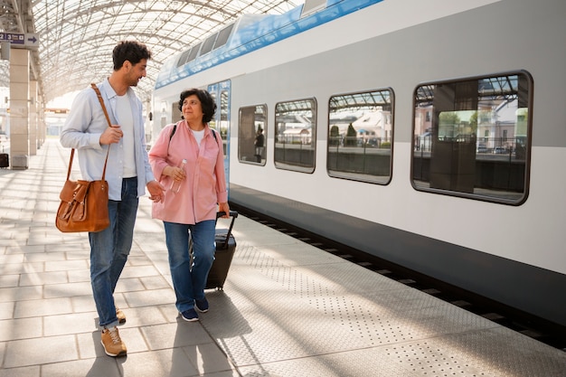 Foto gratuita persone a figura intera che viaggiano in treno