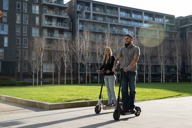 Full shot people traveling with electric scooters in city