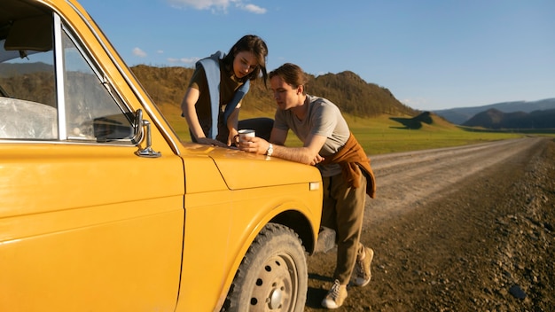 Full shot people with yellow car