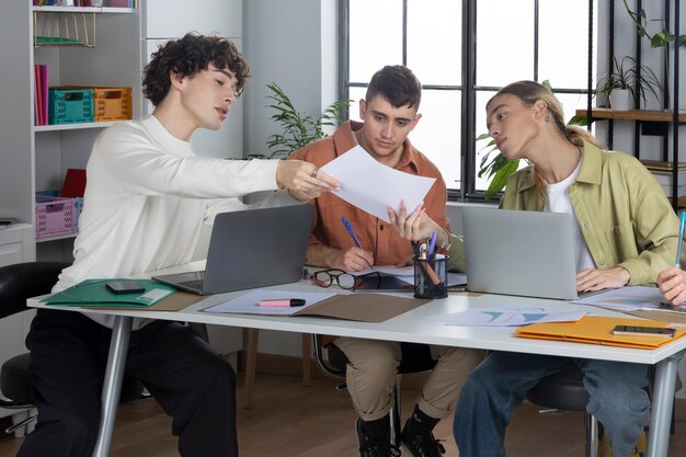 Full shot people working together at desk