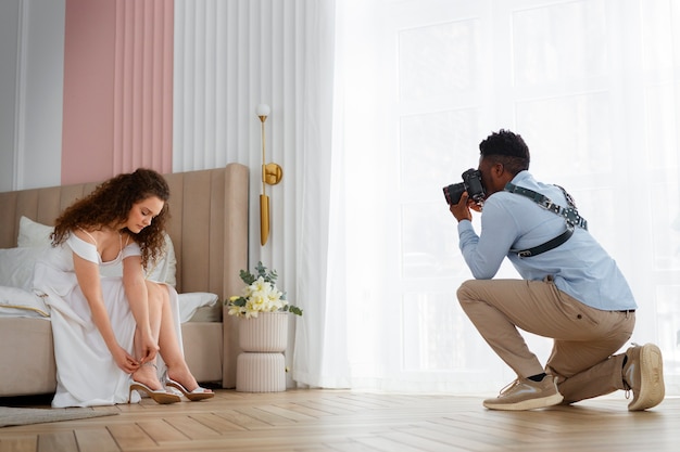 Foto gratuita fotografo a tutto campo che scatta foto della sposa