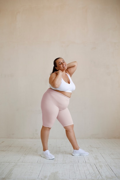 Free photo full shot plus size model posing in studio