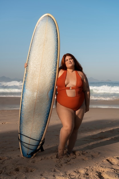 海辺でポーズをとっているフルショットのプラスサイズの女性