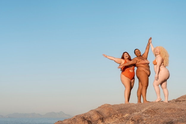 Бесплатное фото Женщины в больших размерах позируют на берегу моря.