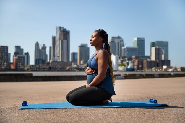 Full shot pregnant woman doing sport outdoors