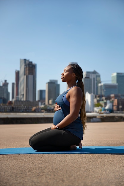 Free photo full shot pregnant woman doing sport outdoors