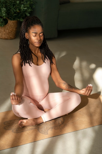 Free photo full shot pregnant woman meditating