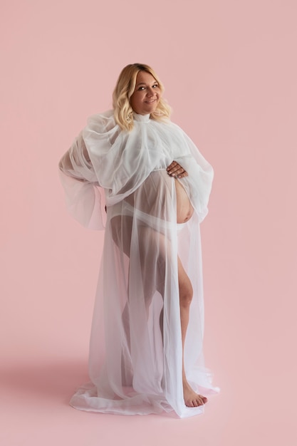 Full shot pregnant woman posing in studio