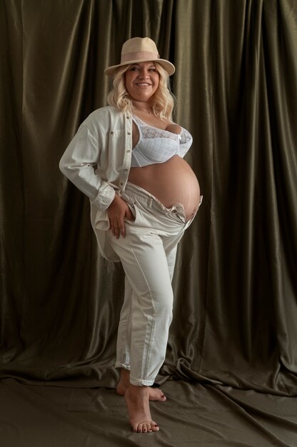 Full shot pregnant woman posing in studio