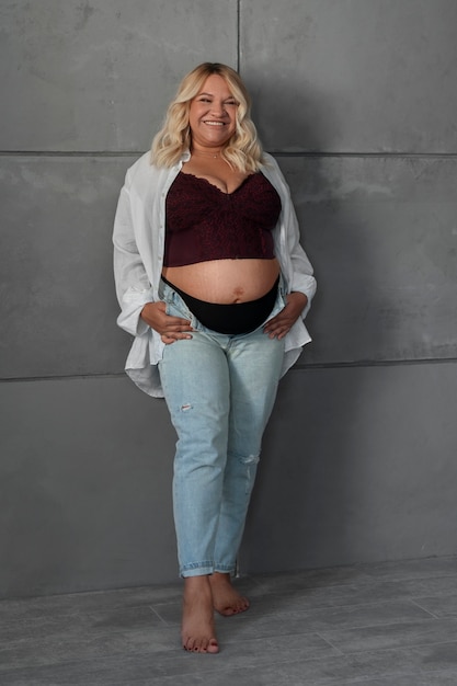 Full shot pregnant woman posing in studio