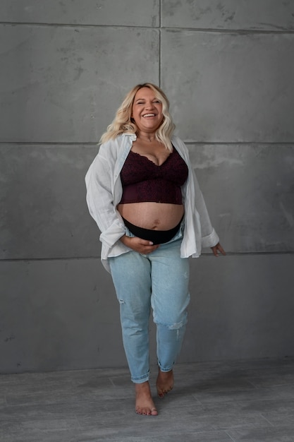 Free photo full shot pregnant woman posing in studio