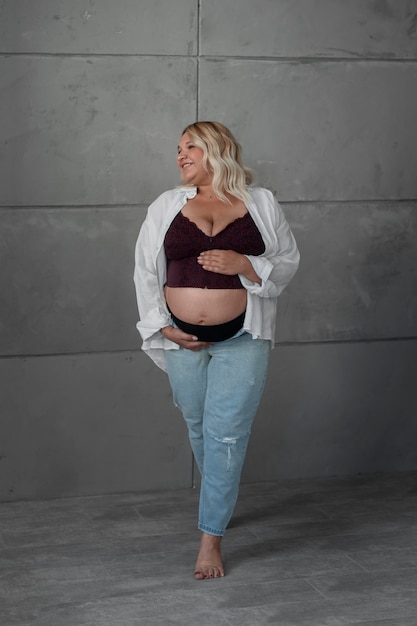 Free photo full shot pregnant woman posing in studio