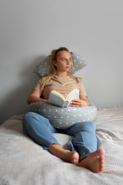 Полный снимок беременной женщины с помощью подушки для кормления