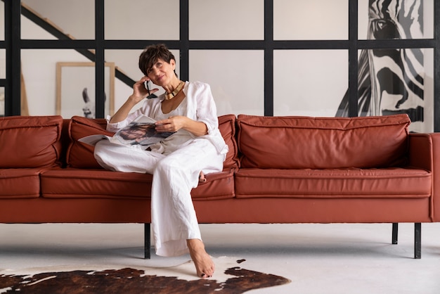 Foto gratuita donna ricca del colpo pieno che si siede a casa