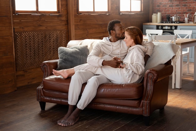 Full shot romantic couple on couch