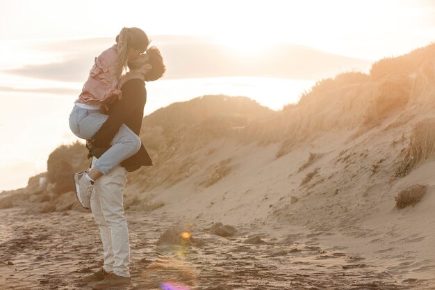 Full shot romantic couple kissing at seaside