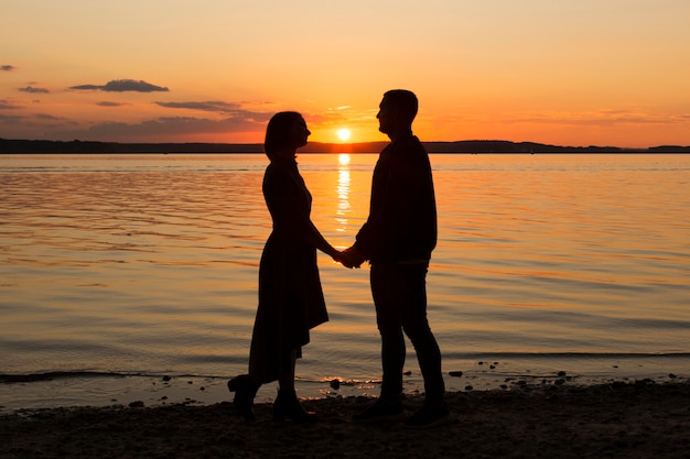 full shot romantic couple at seaside