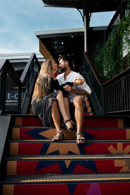 階段に座っているフルショットのロマンチックなカップル