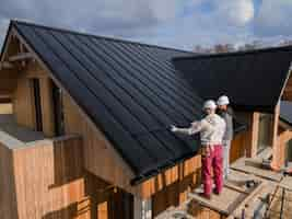 Free photo full shot roofers working together with helmets