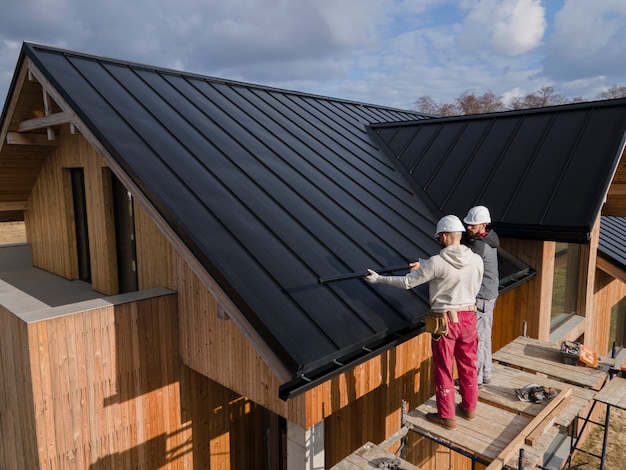 Full shot roofers working together with helmets