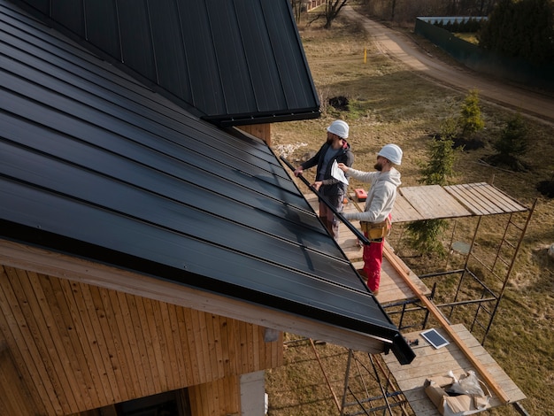 Full shot roofers working with helmets