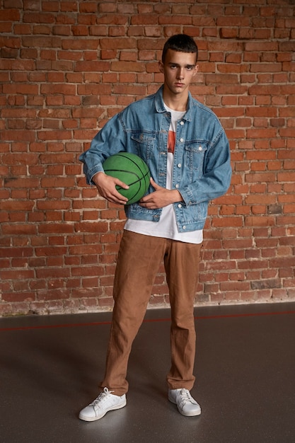 Free photo full shot sad boy holding ball at school